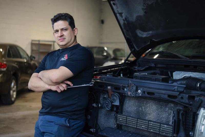 Mecánico de A&A con los brazos cruzados junto a un motor