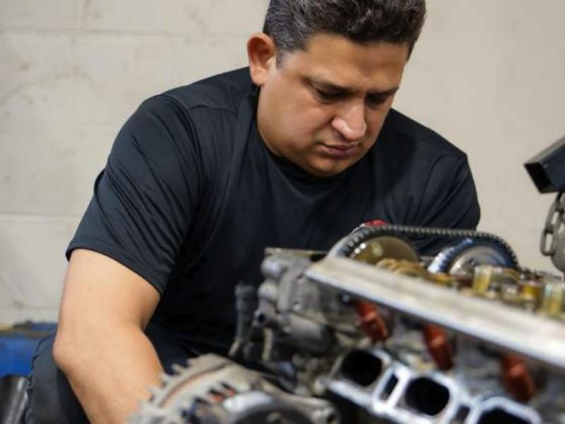 Mecánico de A&A Motor Group trabajando en la cabeza de un motor